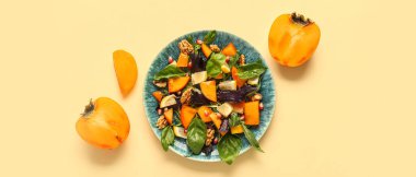 Sarı zemin üzerinde hurma olan lezzetli bir salata tabağı.