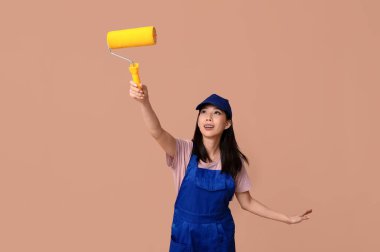 Kahverengi arka planda yuvarlanan Asyalı kadın ressam