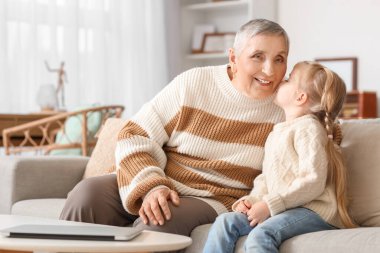 Evde büyükannesini öpen tatlı küçük bir kız.