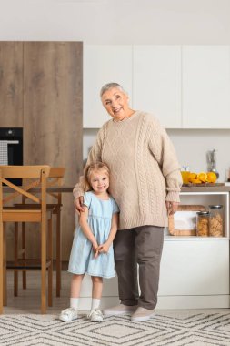 Mutfakta büyükannesiyle kucaklaşan tatlı küçük kız.