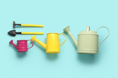 Mavi arka planda bahçe tırmığı ve küreği olan su kutuları.