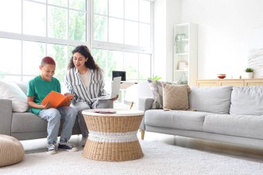 Annesiyle birlikte evde ödev yapan küçük Afro-Amerikalı çocuk.