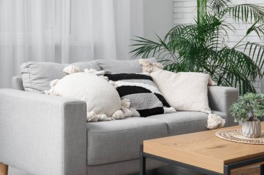 Oturma odasında şık yastıkları olan gri kanepe.