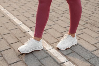 Asfalt yolda bir kadın başlangıç çizgisinde yürüyor. Yeni başlangıç kavramı