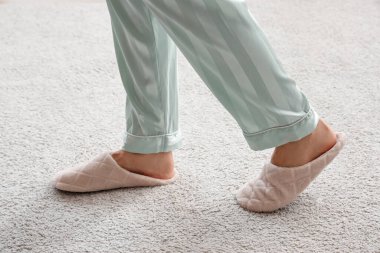 Yumuşak halıda yürüyen terlikli bir kadın. Yeni başlangıç konsepti