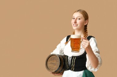 Güzel mutlu Ekim Festivali garsonu. Fıçı bira ve bej arka planda bir kupa bira.