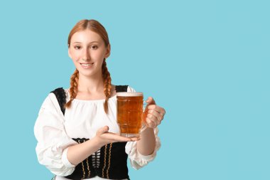 Güzel mutlu Ekim Festivali garsonu mavi arka planda bir kupa birayla