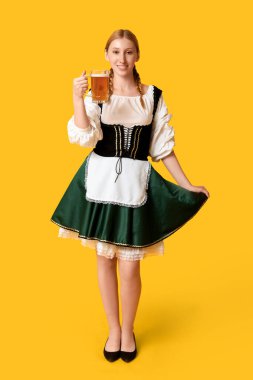 Güzel mutlu Ekim Festivali garsonu. Sarı arka planda bir kupa birayla.