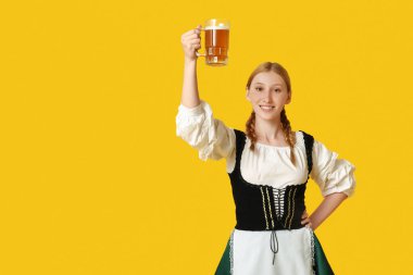 Güzel mutlu Ekim Festivali garsonu. Sarı arka planda bir kupa birayla.