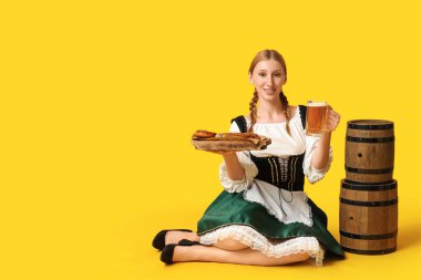 Bira fıçıları ve sarı arka planda oturan geleneksel yemek tabağıyla mutlu Ekim Festivali garsonu.