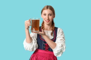 Güzel mutlu Ekim Festivali garsonu mavi arka planda bir kupa birayla