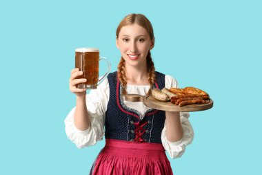 Güzel mutlu Ekim Festivali garsonu, birası ve mavi arka planda geleneksel yemekleri var.