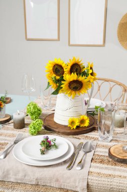 Güzel ayçiçekleri, çiçek dekoru ve mumlarla servis edilen yemek masası.