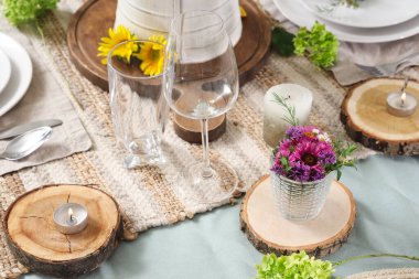 Ayçiçekleri, çiçek dekoru ve mumlarla servis edilen güzel bir masa.