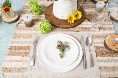 Ayçiçekleri, çiçek dekoru ve mumlarla servis edilen güzel bir masa.