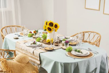 Güzel ayçiçekleri, çiçek dekoru ve mumlarla servis edilen yemek masası.