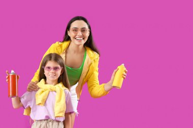 Küçük kız ve annesi mor arka planda sprey boya kutularıyla