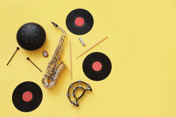 stock image Different musical instruments and vinyl disks on yellow background