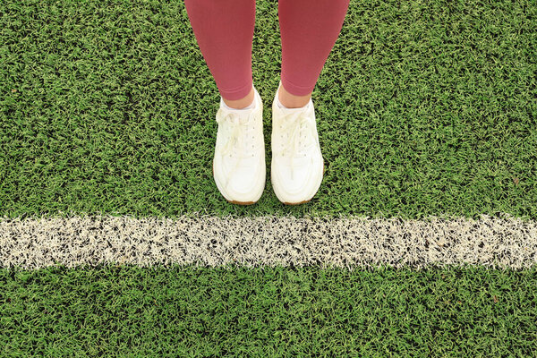 Женщина, стоящая на траве с начальной линией. Концепция нового начала