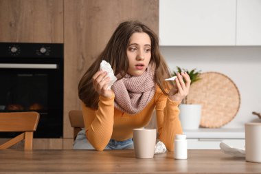 Mutfakta termometresi ve dokusu olan hasta genç bir kadın.