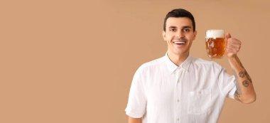 Kahverengi arka planda bira içen yakışıklı genç adam, mesaj için yer var.