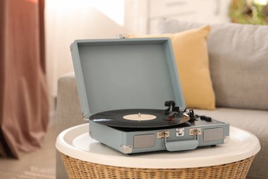 Oturma odasındaki masada vinil diski olan kayıt çalar, yakın plan.