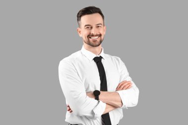 Gri arka planda yakışıklı iş adamı