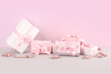 Pembe arka planda yay ve yılan desenli hediye kutuları