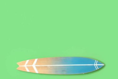 Tahta sörf tahtası yeşil duvarda asılı.