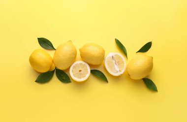 Composition with fresh lemons on yellow background