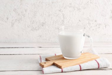 Açık ahşap masada taze sütle cam bardak.