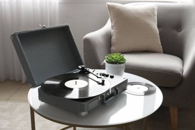 Oturma odasındaki masada vinil diski olan kayıt çalar
