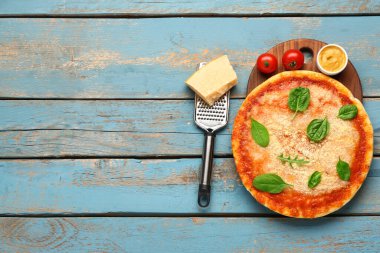 Parmesan peynirli, fesleğenli, soslu ve rendelenmiş lezzetli pizza.