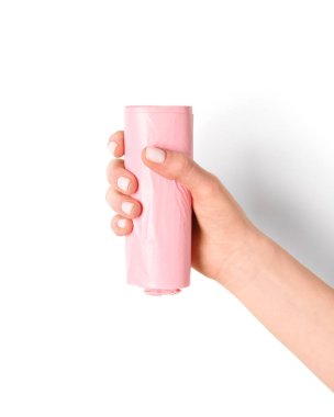 Beyaz arka planda çöp torbası rulosu tutan kadın.