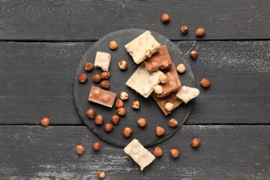 Koyu ahşap arka planda fındıklı farklı lezzetli çikolata.