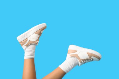 Renkli arka planda şık spor ayakkabılı kadın bacakları