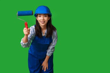 Yeşil arka planda yuvarlanan Asyalı kadın ressam