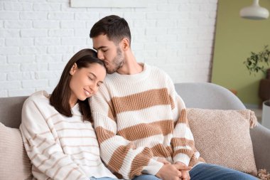 Genç adam sevgili kız arkadaşını öpüyor.