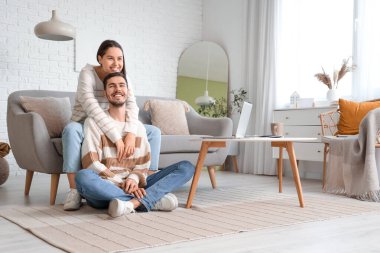 Evde sevgili erkek arkadaşına sarılan genç bir kadın.