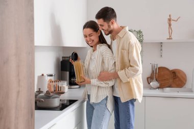 Mutlu genç çift mutfakta yemek hazırlıyor.