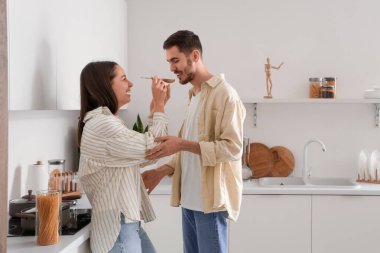 Mutlu genç çift mutfakta yemek hazırlıyor.