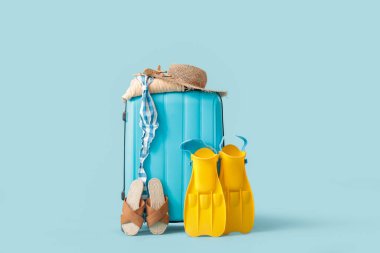 Bavul, şapka ve yüzgeçler mavi arka planda