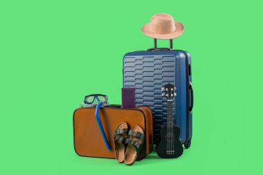 Pasaportlu bavullar ve yeşil arka planda aksesuarlar. Seyahat kavramı