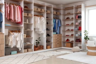 Soyunma odasının içinde şık kıyafetler ve aksesuarlar var.