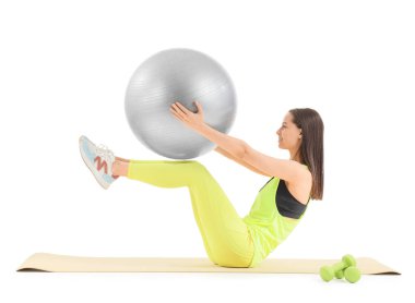 Beyaz arka planda spor yapan genç bir kadın.