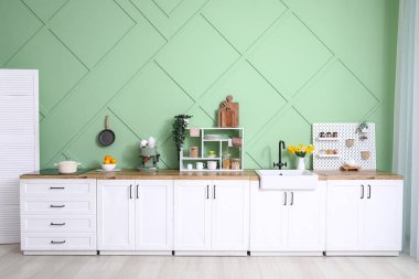 Modern mutfağın içinde şık bir tezgah, soba ve lavabo var.