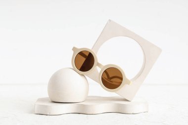 Işık arka planında şık güneş gözlükleri ve sıva podyumları