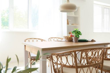 Odanın içinde ahşap masa, sandalyeler ve asılı lamba var.