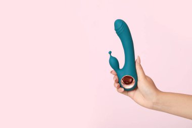 Pembe arka planda kadın el vibratörü, yakın plan.