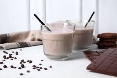 Açık mavi masada tatlı çikolatalı süt ve lezzetli kurabiyeler.